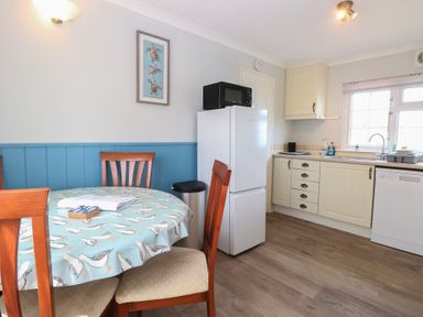 A kitchen with a table and chairs at Seaward in Trimingham