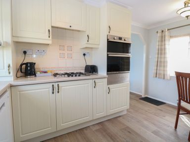 A kitchen with cabinets and a gas stove at Seaward in Trimingham