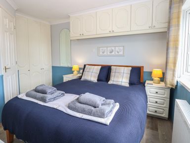 A bedroom with a bed and bedside tables at Seaward in Trimingham