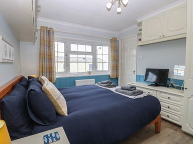 A bedroom with a bed and television at Seaward in Trimingham