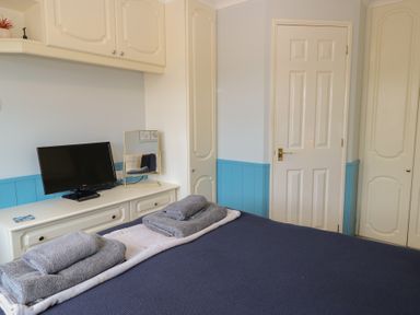 A bedroom with a bed and television at Seaward in Trimingham