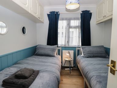 A bedroom with two beds and a lamp at Seaward in Trimingham