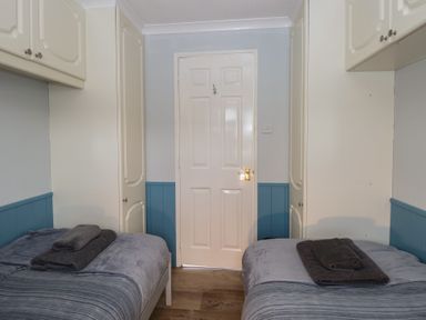 A bedroom with two beds and a door at Seaward in Trimingham