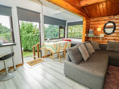 A snug area with a couch and dining table at Babbling Brook in Bron Aber near Blaenau Ffestiniog