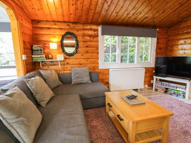A snug with a sofa and television at Babbling Brook in Bron Aber near Blaenau Ffestiniog