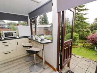 A kitchen with a microwave and fridge at Babbling Brook in Bron Aber near Blaenau Ffestiniog