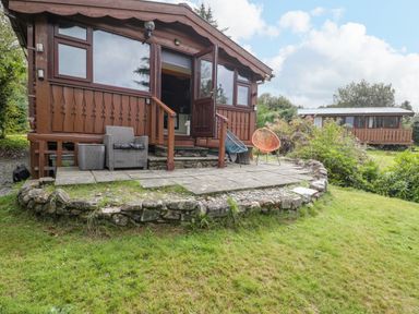 A cabin with a patio and outdoor furniture at Babbling Brook in Bron Aber near Blaenau Ffestiniog
