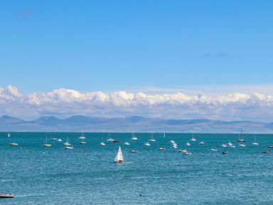A sea view with many boats floating on water and mountains in the background at Angorfa Bach in Abersoch