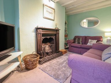 A living room with a fireplace and sofa at Preswylfa in Ffestiniog