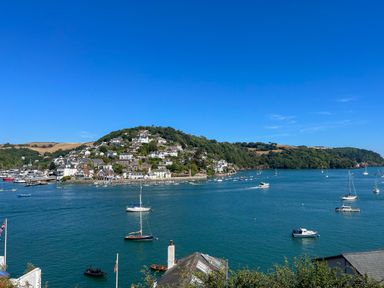 A coastal town with buildings and boats on the water at Upper Tremorvah in Dartmouth