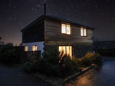 A house with lights on at night at 3 Praa Cove in Praa Sands