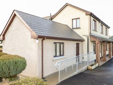 Exterior of a two-story house with a single-story extension and metal railing at Derriens Farmhouse in Letterbreen County Fermanagh