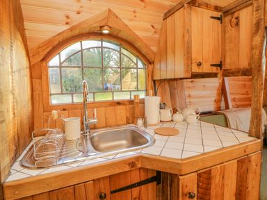 A wooden kitchen corner with a stainless steel sink and a window above at The Wagon at Burrow Hill in Ottery St Mary
