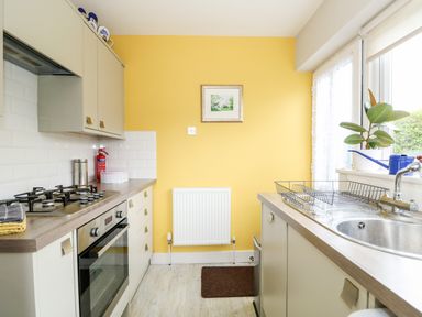 A kitchen with a gas stove oven sink and countertop at The Lobster Pot in Overstrand