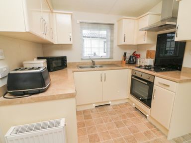 A kitchen with a toaster microwave sink oven and cabinets at The Bobbin Number 11 South Lakeland Leisure Village near Carnforth
