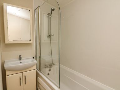 A bathroom with a sink cabinet mirror and bathtub with shower at The Bobbin Number 11 South Lakeland Leisure Village near Carnforth
