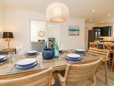A dining table set with plates glasses and cutlery in a kitchen and dining area at Greenbank in Woolacombe