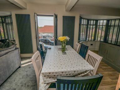 A dining room with a table covered by a heart patterned tablecloth and chairs around it at Nightingales in Bridlington