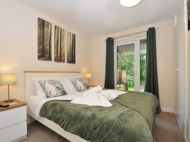 A bedroom with a bed and a door leading outside at Hideaway Cottage St Ann's Chapel, Cornwall