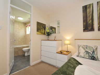 A bedroom with a bed and dresser at Hideaway Cottage, St Ann's Chapel, Cornwall