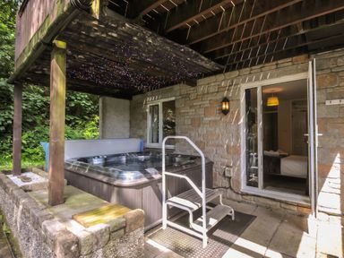 A hot tub with steps on a patio at Hideaway Cottage, St Ann's Chapel, Cornwall
