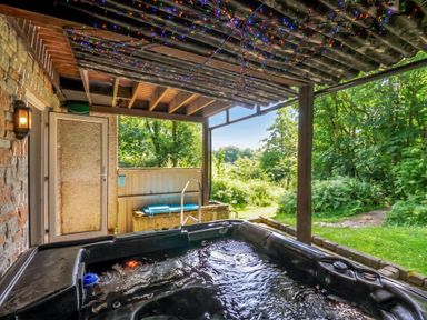 A hot tub on an outdoor terrace at Hideaway Cottage St Ann's Chapel, Cornwall