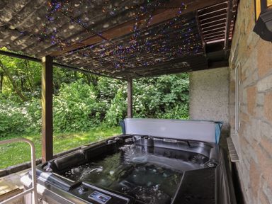 An outdoor area with a hot tub and lights at Hideaway Cottage in St Ann's Chapel, Cornwall