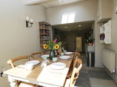 A dining room with a table set for meal at Mallards in Bourton-On-The-Water