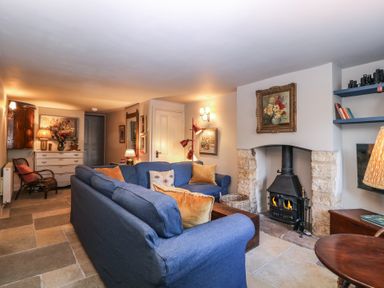 A living room with a fireplace and a sofa at Mallards in Bourton-On-The-Water