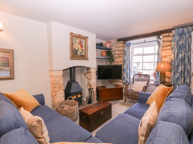A living room with a fireplace and sofa at Mallards in Bourton-On-The-Water