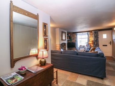 A living room with a sofa and table at Mallards in Bourton-On-The-Water