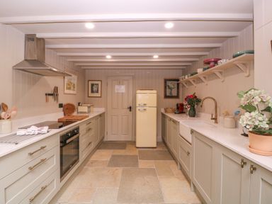 A kitchen with cabinets and appliances at Mallards in Bourton-On-The-Water