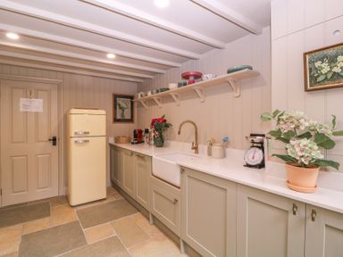 A kitchen with a refrigerator and cabinets at Mallards in Bourton-On-The-Water