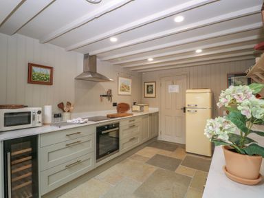 A kitchen with appliances and cabinetry at Mallards in Bourton-On-The-Water