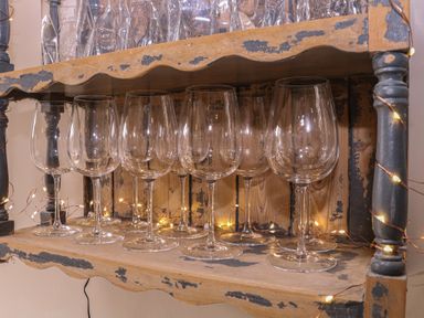 A shelf with wine glasses and string lights at Mallards in Bourton-On-The-Water