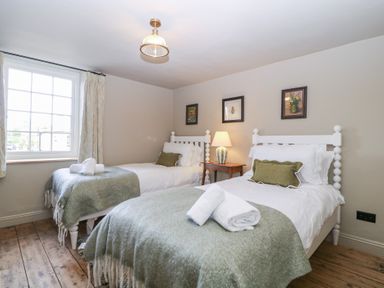 A bedroom with two beds and a window at Mallards in Bourton-On-The-Water