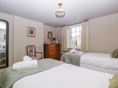 A bedroom with two beds and a dresser at Mallards in Bourton-On-The-Water