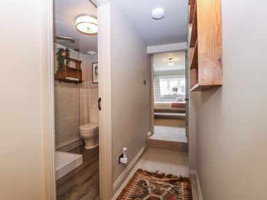 A bathroom with a toilet and shower viewed from a hallway at Mallards Bourton-On-The-Water