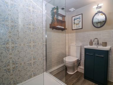 A bathroom with a shower, toilet, and sink at Mallards in Bourton-On-The-Water
