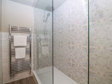 A bathroom with a shower and towel rail at Mallards in Bourton-On-The-Water
