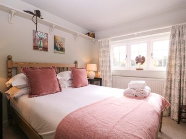 A bedroom with a bed and decorative pillows at Mallards in Bourton-On-The-Water