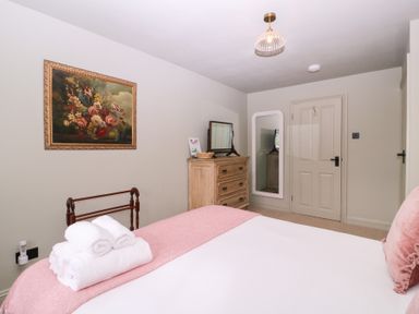 A bedroom with a bed and dresser at Mallards in Bourton-On-The-Water
