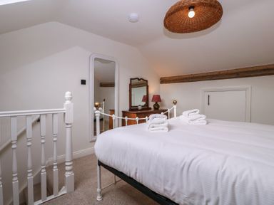 A bedroom with a bed and mirror at Mallards Bourton-On-The-Water