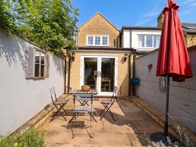 A garden area with a table and chairs at Mallards, Bourton-On-The-Water