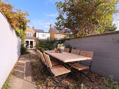 A garden with a dining table and chairs at Mallards in Bourton-On-The-Water