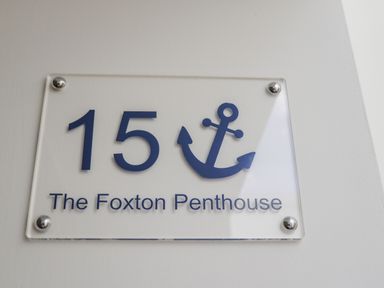 A sign with the number 15 and an anchor symbol above the text The Foxton Penthouse