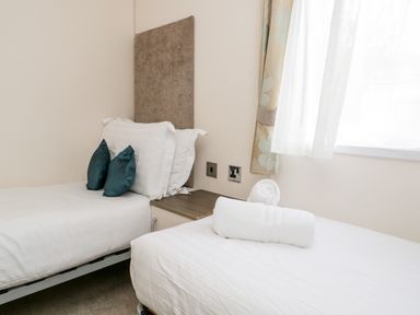 A bedroom with two single beds with pillows and rolled towels at Number 10 in Warton
