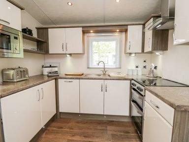 A kitchen with countertop appliances cabinets and a window above the sink at Number 10 in Warton