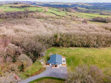 A single building with a gray roof surrounded by fields and trees at Quantock Barn Stockland near Honiton