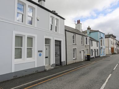 A street with a row of attached houses painted in different colors at Cobblers Cottage in Beaumaris